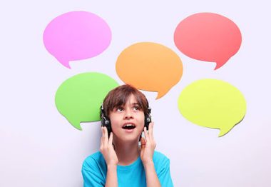 Language learning concept: Schoolboy with earphones and speech bubbles around him.